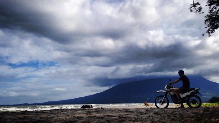 Motorcycle adventure beneath the shadow of Volcán Maderas on Ometepe Island, Nicaragua.