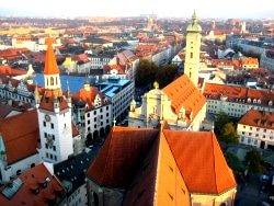 Munich rooftops from above, red tiles and church towers running to the horizon