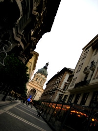 A Budapest side street at dusk, a domed church closing off the far end